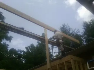 Carpenter setting a ridge beam over a new addition frame — Ice Dam Removal by Roofing Brothers in Mendenhall