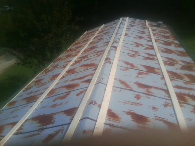 Rusted metal roof panels with new wood purlins before replacement — Storm Damage Roof Repair in Mendenhall by Roofing Brothers