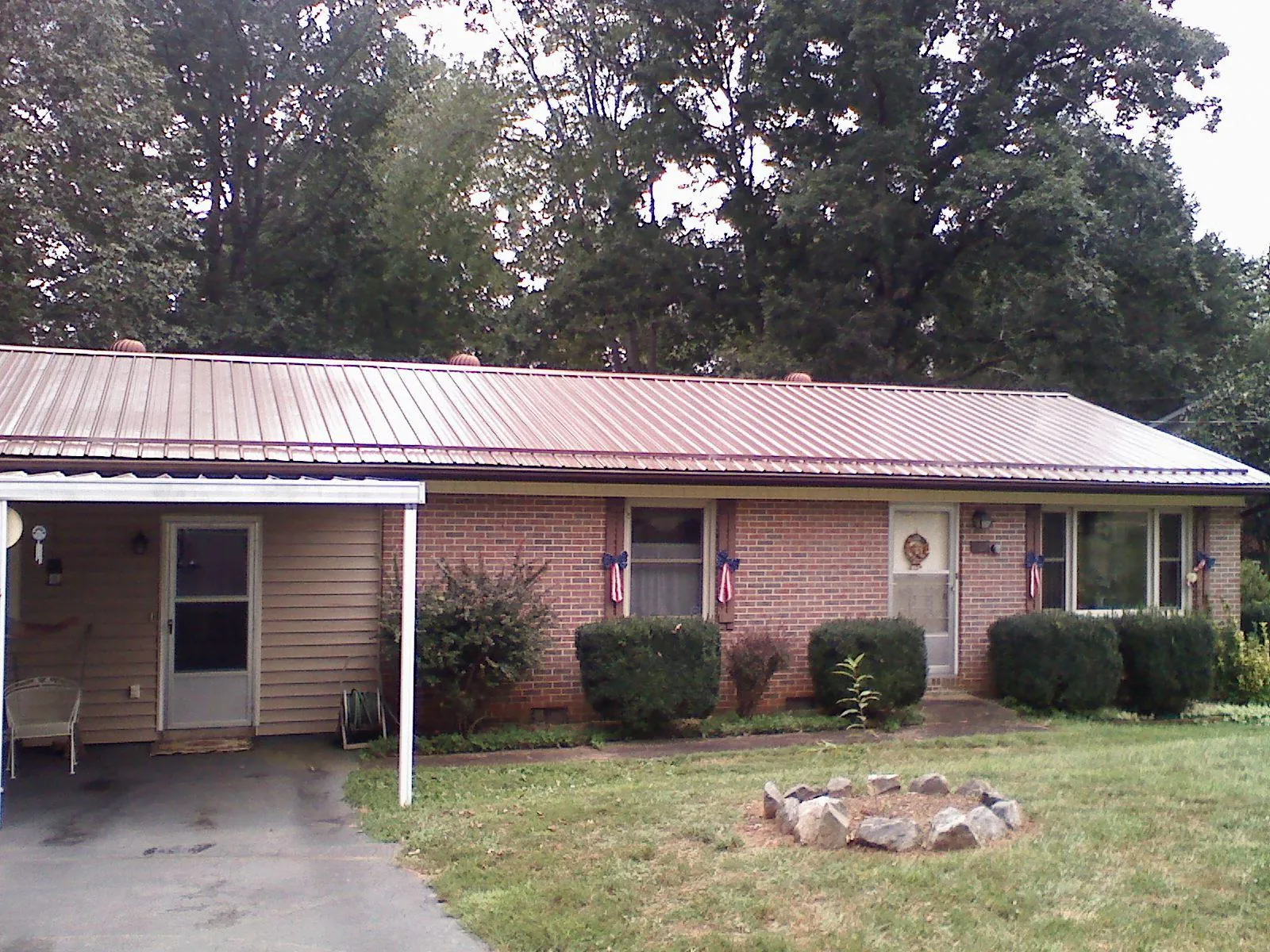 Bronze metal roof and carport on a brick ranch home — Roof Repair work by our crew in Mendenhall